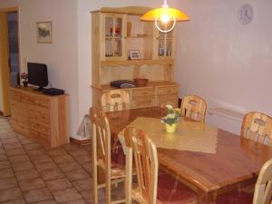Un comedor con mesa y sillas de madera. en Ferienhaus in Dornumersiel 20-069, en Dornumersiel