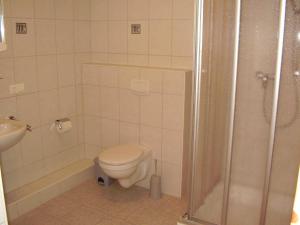 un baño con inodoro y ducha en Ferienhaus in Dornumersiel 20-069, en Dornumersiel