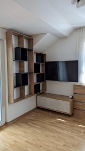 an empty living room with a flat screen tv at Apartman ANA in Žabljak