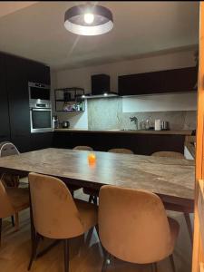 uma cozinha com uma grande mesa de madeira e cadeiras em Appart hyper centre Font Romeu em Font Romeu Odeillo Via