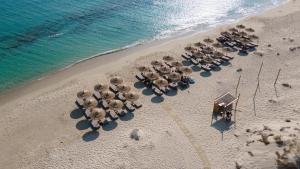 una vista aerea di una spiaggia con un gruppo di ombrelloni di Sundunes Hotel Naxos a Plaka