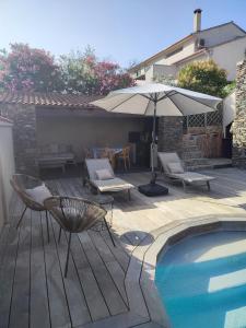 a patio with chairs and an umbrella and a pool at Villa moderne avec piscine privative in Biguglia