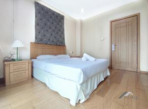 a bedroom with a large white bed and a wooden floor at Mciti Suites by Evernent in Miri +25 photos