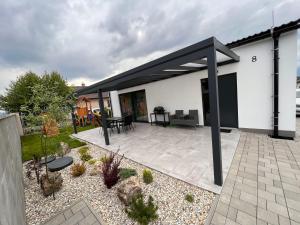 a white house with a black roof and a patio at Apartment house Tatras in Liptovský Mikuláš