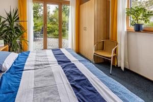 a bedroom with a bed and a chair and a window at Geräumige Ferienwohnung mit Garten in Denkingen