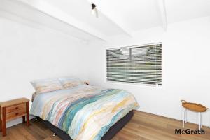 un dormitorio con una cama y una ventana en Maple House, en Emerald Beach