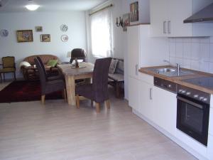 uma cozinha e sala de jantar com mesa e cadeiras em Ferienhaus in Dornumersiel 20-157 em Dornumersiel