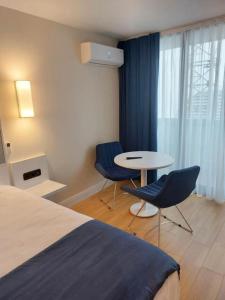 Habitación de hotel con cama, mesa y sillas en The best view Apartment Orbi city, en Batumi