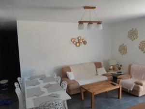 Una sala de estar con un sofá y sillas y una mesa. en la java, en Saint-Cyran-du-Jambot