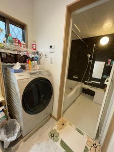uma máquina de lavar roupa num quarto com um espelho em 新世界步行5分钟 难波电车2分钟一户建 带停车场 em Osaka