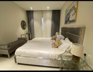 een slaapkamer met een wit bed en een glazen tafel bij Al Aryam Hawana Salalah in Salalah