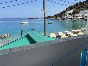 a beach with umbrellas and people in the water at Notos Rooms in Loutro +32 photos