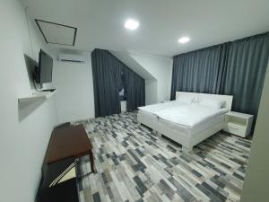 a bedroom with a bed and a flat screen tv at Hotel Diana in Cahul