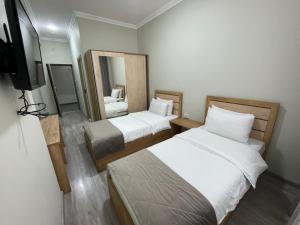 a small room with two beds and a television at Airport Hotel 24 in Tashkent