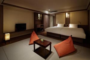 ein Hotelzimmer mit einem Bett und einem TV in der Unterkunft Laforet Hakone Gora Yunosumika in Hakone