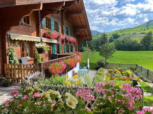 a garden in front of a house with flowers at Alpenchalet Spiher Gstaad Ferienwohnung im Parterre in Gstaad