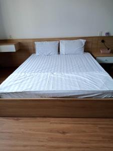 a large bed with white sheets and pillows on it at Khôi Đại Hotel in Buon Ma Thuot