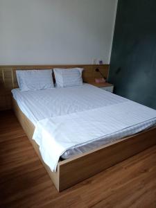 a bed with white sheets and pillows in a room at Khôi Đại Hotel in Buon Ma Thuot