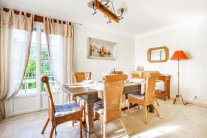 uma sala de jantar com mesa e cadeiras em Villa Regina 500 métres de la plage em La Garonnette-Plage