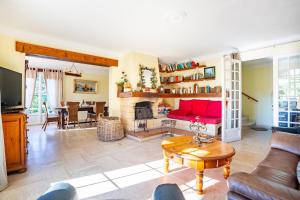 uma sala de estar com um sofá vermelho e uma lareira em Villa Regina 500 métres de la plage em La Garonnette-Plage