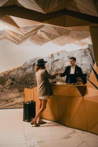 a woman shaking hands with a man at a desk at Amante Narikala Boutique Hotel in Tbilisi City