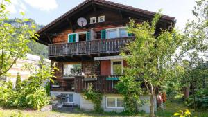 una casa in legno con balcone sopra di Zimmer für Backpaking - Das gemütliche Haus des Grossvaters - Bergheimat - Ganz einfach - ganz unkompliziert - ganz relaxd a Linthal