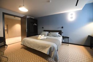 a bedroom with a large bed and a bathroom at Victoria by Petit Chic in Mellieħa