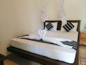 ein Schlafzimmer mit einem Bett und zwei weißen Handtüchern in der Unterkunft Induwara Safari Resort in Udawalawe