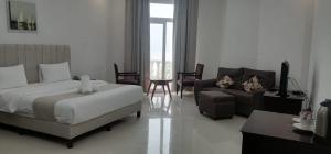 1 dormitorio con 1 cama y sala de estar con sofá en Beach Resort Salalah, en Salalah