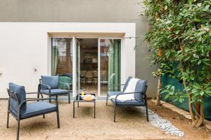 a group of chairs sitting on a patio at Le Nouveau Monde - Appartement Chic et Confortable in Saint-Priest