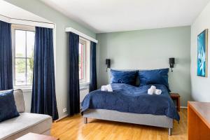 a bedroom with a blue bed and a window at Storebaug Hotell & Kro in Moss