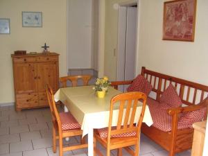 Un comedor con una mesa y sillas blancas. en Ferienwohnung in Dornumersiel 20-068, en Dornumersiel