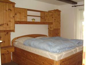 1 cama en un dormitorio con armarios de madera en Ferienwohnung in Dornumersiel 20-068, en Dornumersiel