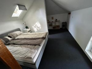ein Schlafzimmer mit einem Bett in einem weißen Zimmer in der Unterkunft modernes „Tiny House“ in Plewen