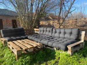 two couches sitting on a wooden bench in a yard at modernes „Tiny House“ in Pleven