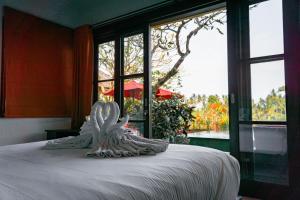 een slaapkamer met een wit bed en een raam bij Uma Stana Villa in Ubud