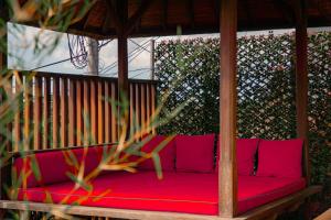un sofá rojo en un cenador en Uma Stana Villa, en Ubud