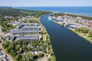 - une vue aérienne sur un complexe au bord d'une rivière dans l'établissement Wellness Resort & SPA Apartments Dziwnów Riverfront by Renters, à Dziwnów