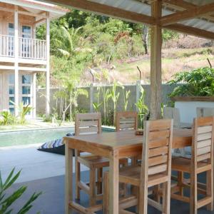 a wooden table and chairs on a patio at Silir Villa "your cozy home" in Mataram