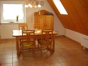 a dining room with a wooden table and chairs at Ferienwohnung in Dornumersiel 20-084 in Dornumersiel