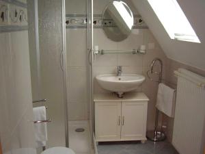 a bathroom with a sink and a shower with a mirror at Ferienwohnung in Dornumersiel 20-084 in Dornumersiel
