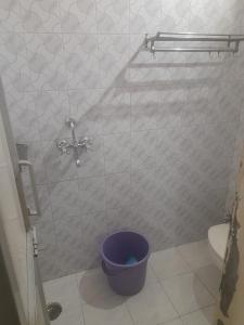 a bathroom with a shower with a purple toilet at IFM Guest House in Amritsar