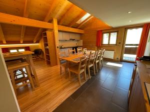 uma cozinha e sala de jantar com mesa e cadeiras em Alpenchalet Weidhaus Gstaad Ferienwohnung im Dachstock, Studio und Zimmer im EG em Gstaad