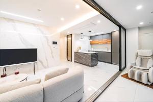 a living room with a white couch and a tv at UH FLAT The SEOCHO in Seoul