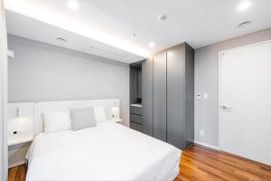 a white bedroom with a white bed and a closet at UH FLAT The SEOCHO in Seoul +55 photos