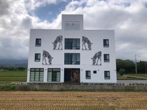 a white building with zebras painted on it at 武暖Zoo親子民宿（新館） in Yilan City
