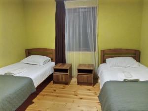 Habitación con 2 camas y ventana en Hotel Kepney en Omalo