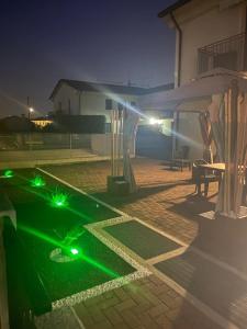 eine Terrasse mit grüner Beleuchtung im Garten in der Nacht in der Unterkunft HOME NUOVA OSTIGLIA in Padernello