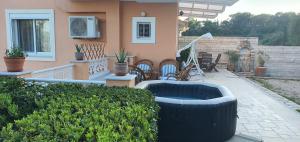 a house with a tub in front of a yard at Villa Miranda in Gouvia