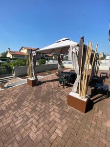 un patio con sombrilla, mesa y sillas en HOME NUOVA OSTIGLIA, en Padernello